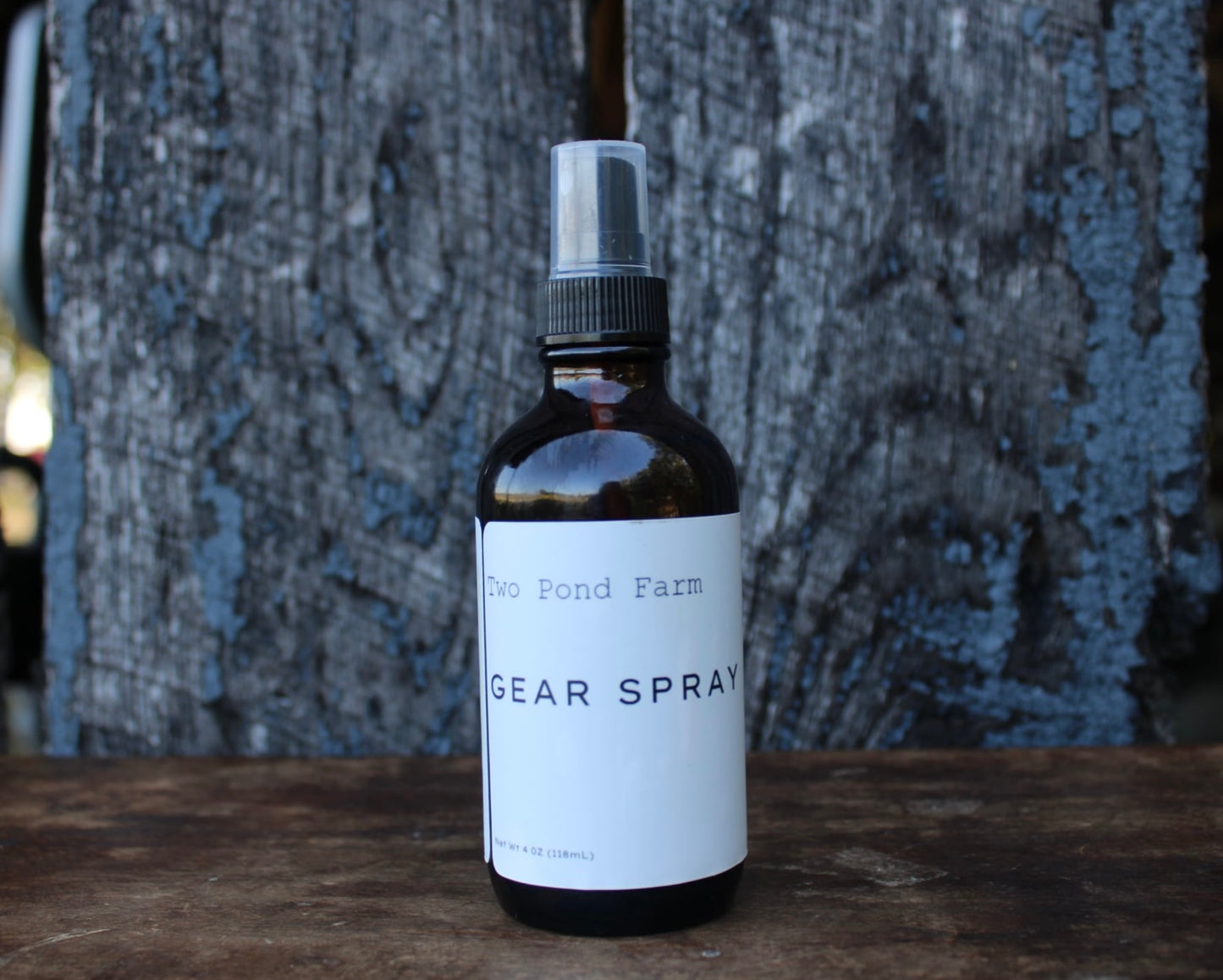 Bottle of 'The Pond Farm Gear Spray' on a wooden surface