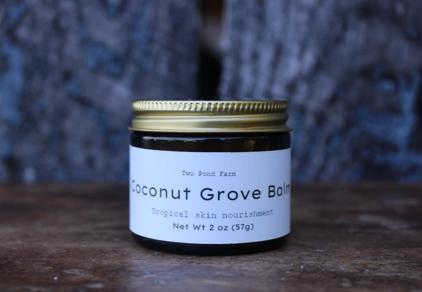 Coconut Grove Balm jar with a white label on a wooden surface