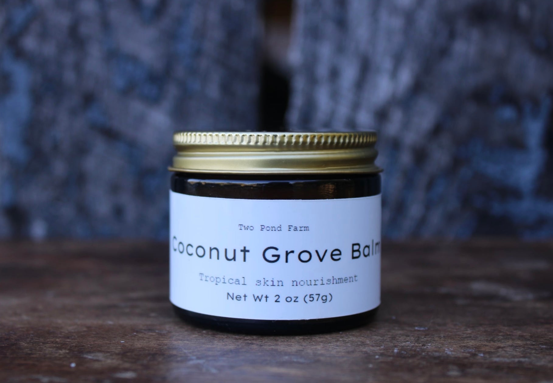 Coconut Grove Balm jar with a white label on a wooden surface