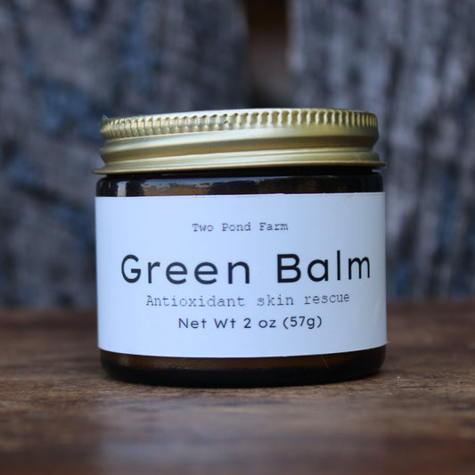 Jar of Green Balm on a wooden table with black wooden background